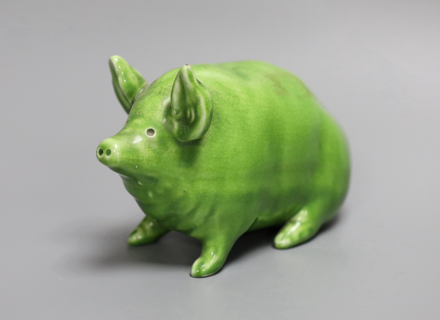 A Wemyss ware pig, decorated in lime green glaze and impressed to the base Wemyss ware RH & S, for Robert Heron & Son of Fife, 16.5cm long, 10cm high.
